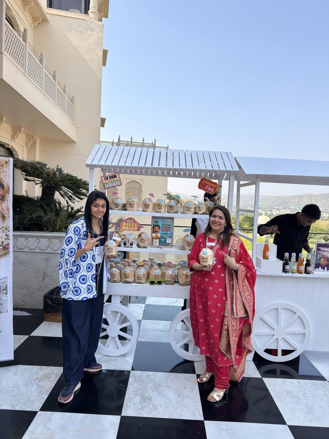 Two guests holding coconuts at the Mr. Coconut CocoCart